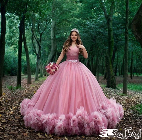 لباس عروس صورتی که به زیبایی با دسته گل صورتی و بنفش، ست شده است.