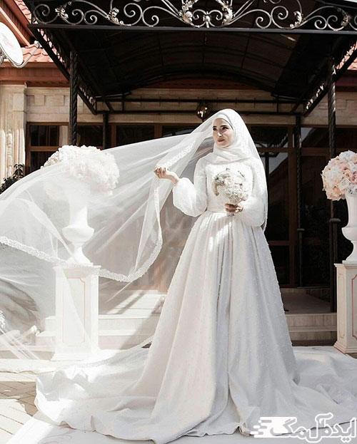دنباله بلند و استین‌های پفی در یک مدل لباس عروس محجبه