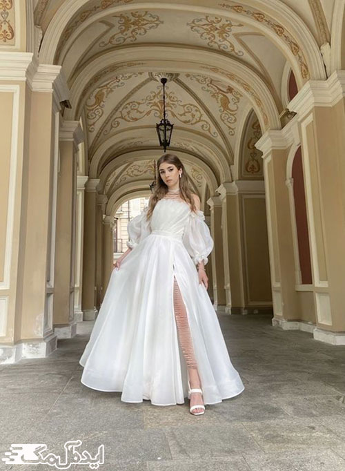 استفاده از پارچه ساده و مرغوب در لباس عروس اروپایی با دامن چاک‌دار نیمه‌پفی
