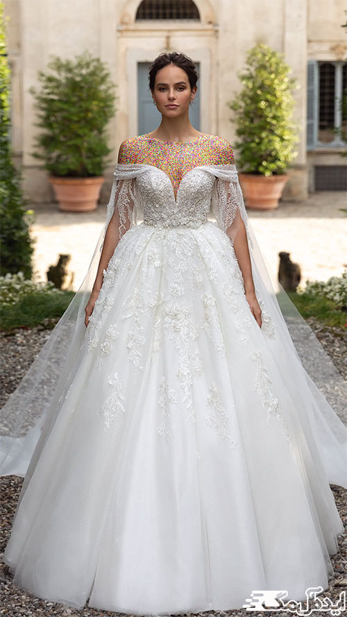 مدل لباس عروس پفی 2023 با شنل تور آویخته شده از آستین‌ها