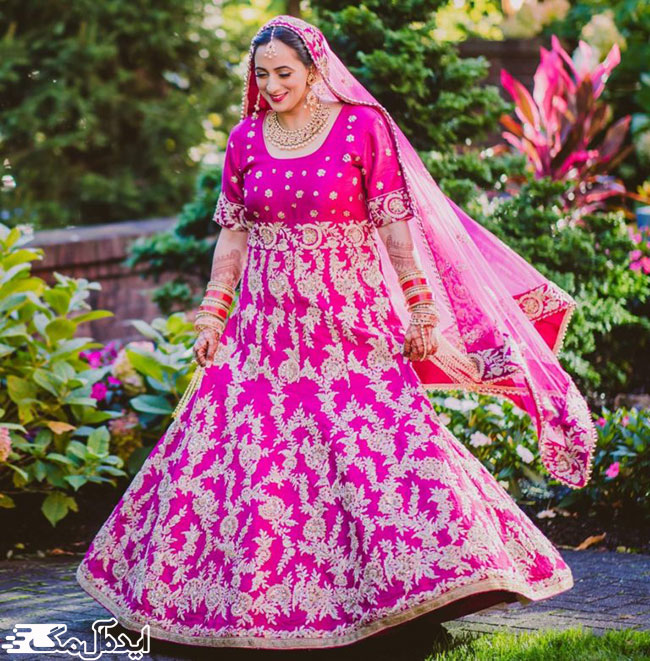 لباس مدل پنجابی با دامن کلوش طرح‌دار به رنگ صورتی شاد و اکسسوری‌های حجیم هندی