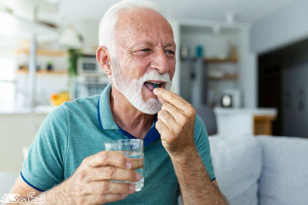 مرد سالمند یک مولتی ویتامین می‌خورد 