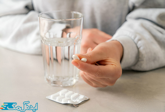 فردی که 2 عدد قرص برای درمان گرفتگی عضلات در دست دارد