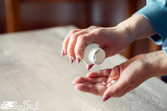 یک زن قرص باکلوفن را از قوطی روی کف دست خود میریزد