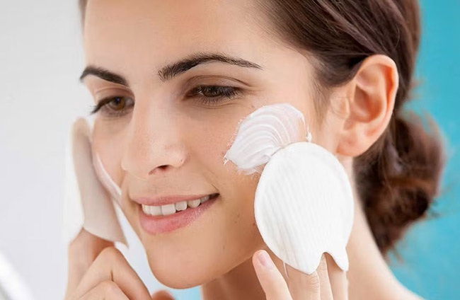 یک زن با پوست خشک به صورتش کرم می زند