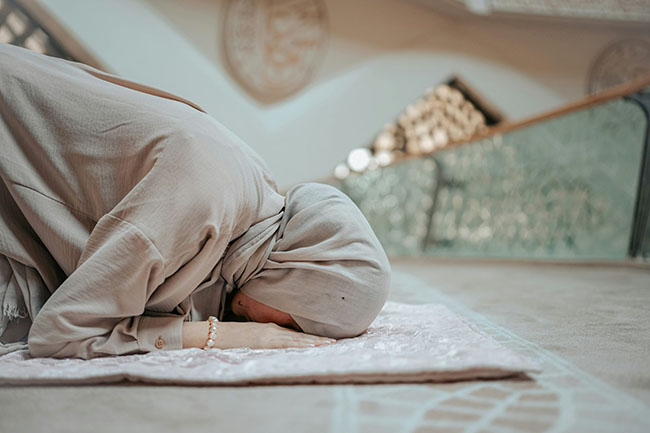 یک زن مسلمان در سجده و مشغول خواندن نماز
