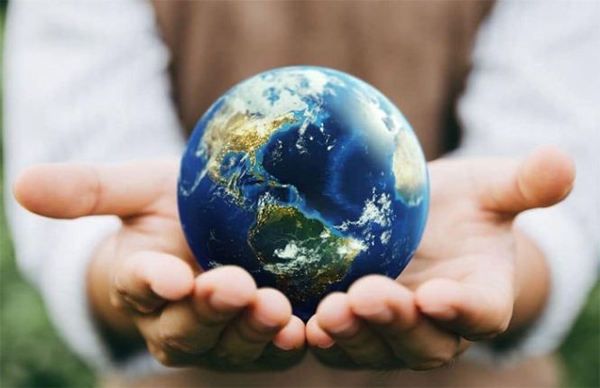 یک نفر کره زمین را در بین دو دست خود گرفته است